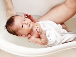 Dad giving his baby a bath
