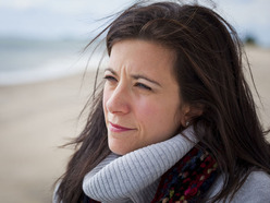 Woman on beach looking thoughtful