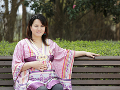a pregnant woman sitting on a park bench with hand on her belly