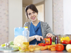woman cutting up fresh fruit and vegetables