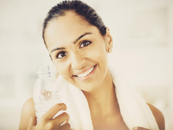 Woman with water and an exercise towel
