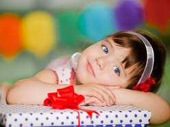 Smiling young girl lying on her front with a wrapped present