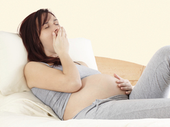 pregnant woman yawning in bed