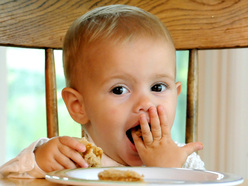 toddler enjoying feeding himself finger foods