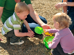 Two children sharing a bucket and spade