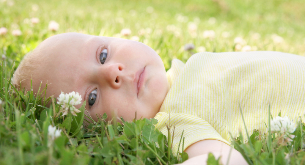 Baby lying on grass with flowers