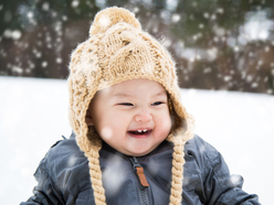 baby dressed in several layers to keep him warm