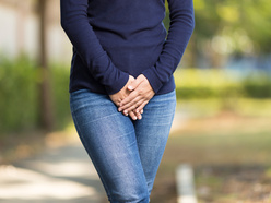 woman with thrush crossing her hands in front of her pants