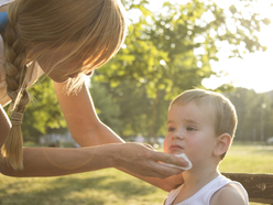 mum wiping the mouth of a child who's just vomited