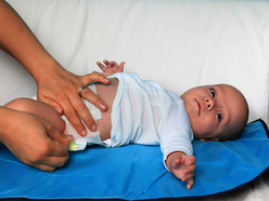 a baby having his nappy changed by a woman