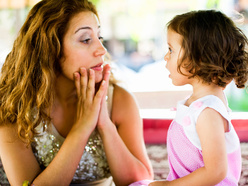 Mum bending down to her daughter's height to listen to her.