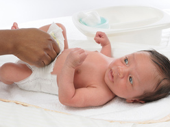 newborn baby having his nappy changed after doing a green poo