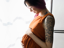 Pregnant woman feeling her bump