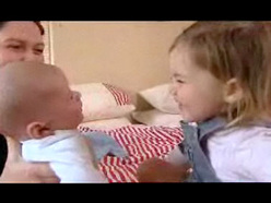 mum introducing newborn to her toddler