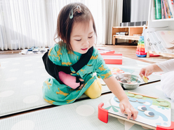 Child with her arm in cast, using her free arm to play with a toy