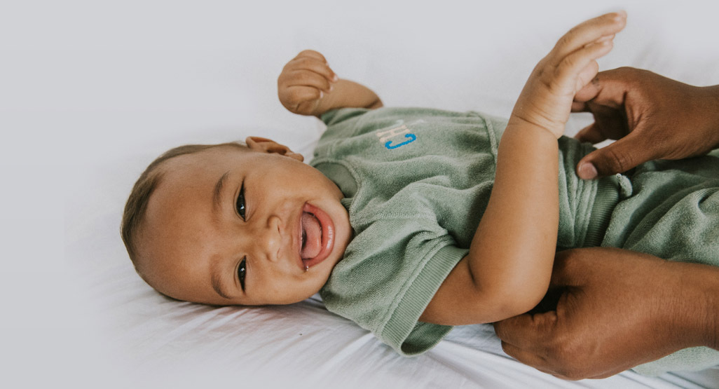 Baby laying on back smiling