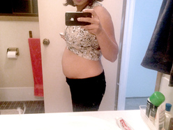 woman 16 weeks pregnant showing her belly